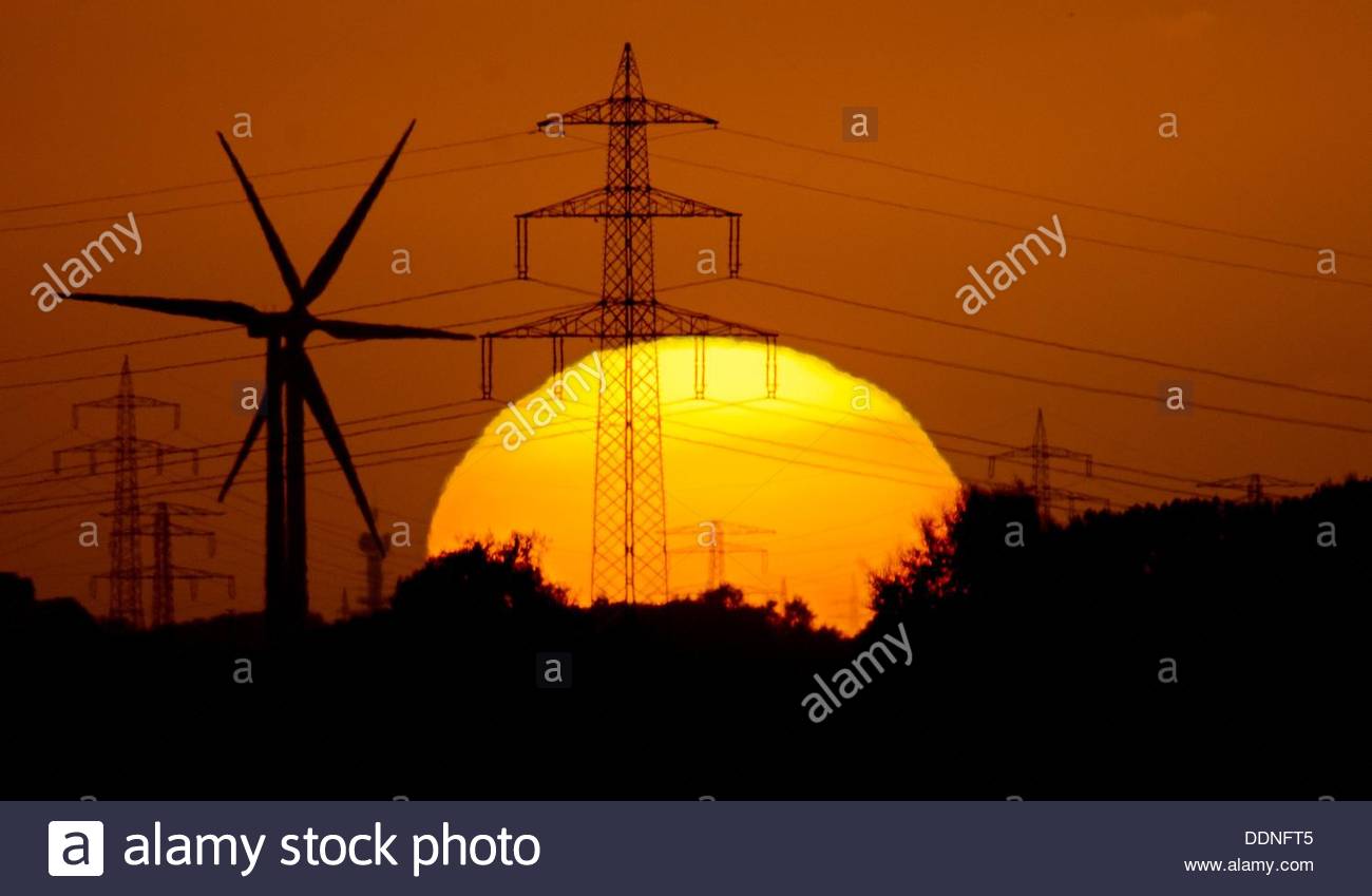 a-high-voltage-transmission-line-and-wind-turbines-silhouette-against-DDNFT5.jpg